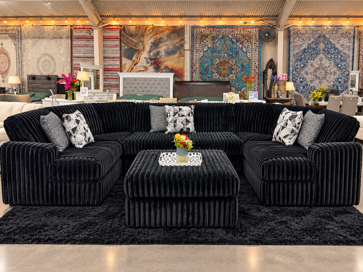 Black channel-tufted sectional with ottoman in the Furniture & Home Design showroom